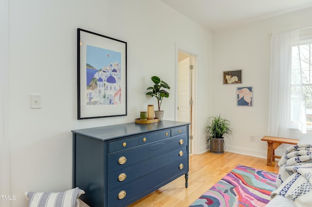 living area with light wood-style flooring and baseboards