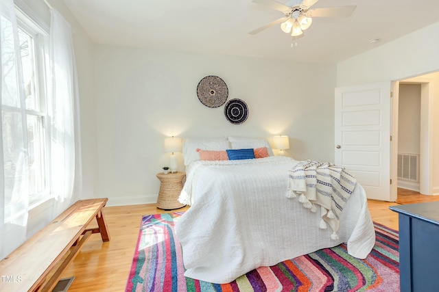 bedroom with visible vents, multiple windows, baseboards, and light wood-style flooring