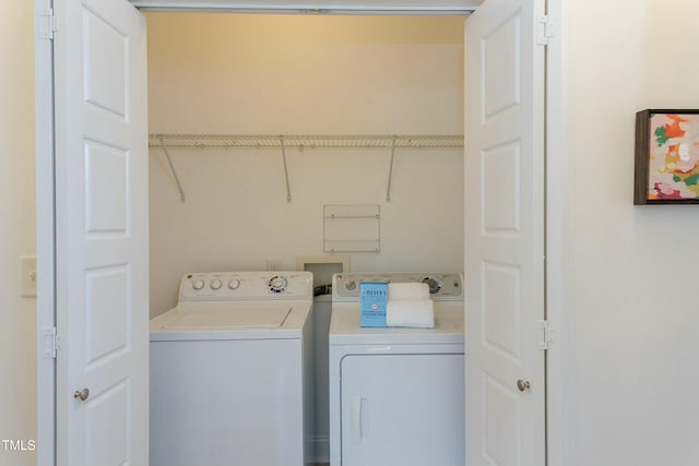 clothes washing area featuring laundry area and washer and clothes dryer