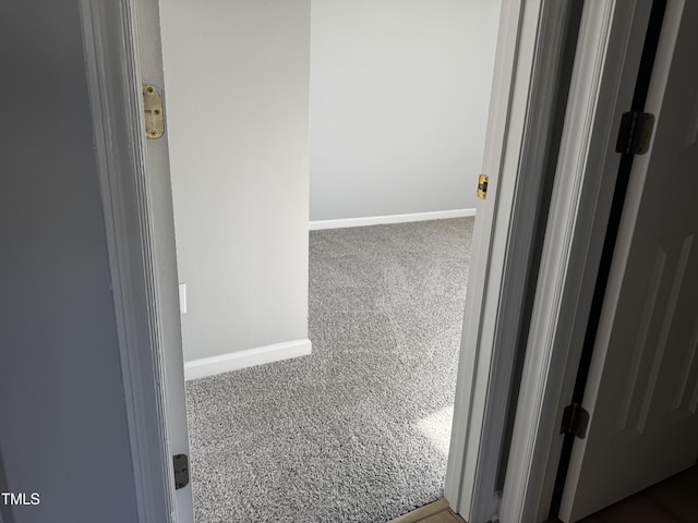 hallway with carpet and baseboards