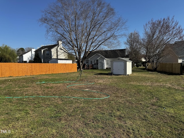 view of yard with a storage shed, an outdoor structure, and fence