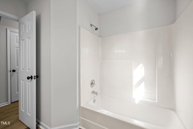 full bath featuring shower / tub combination, baseboards, and wood finished floors