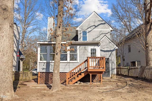 back of property featuring a chimney, a sunroom, and fence