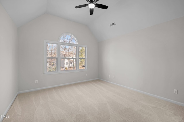 carpeted spare room featuring visible vents, ceiling fan, baseboards, and lofted ceiling