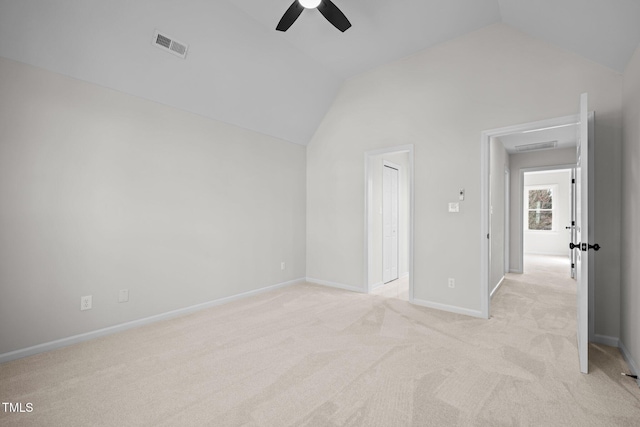 unfurnished bedroom with visible vents, baseboards, light colored carpet, vaulted ceiling, and a ceiling fan