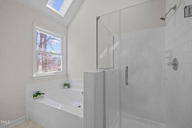 full bathroom with baseboards, vaulted ceiling with skylight, a stall shower, and a bath