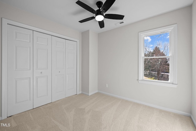 unfurnished bedroom with a ceiling fan, carpet, visible vents, baseboards, and a closet