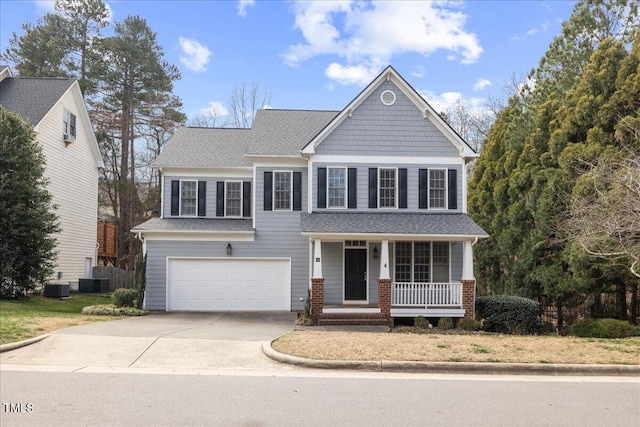 craftsman-style home featuring a porch, central air condition unit, a garage, and driveway