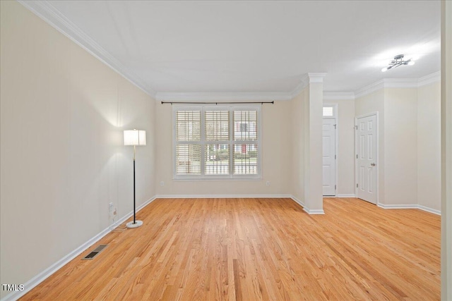 spare room featuring baseboards, crown molding, and light wood-style floors