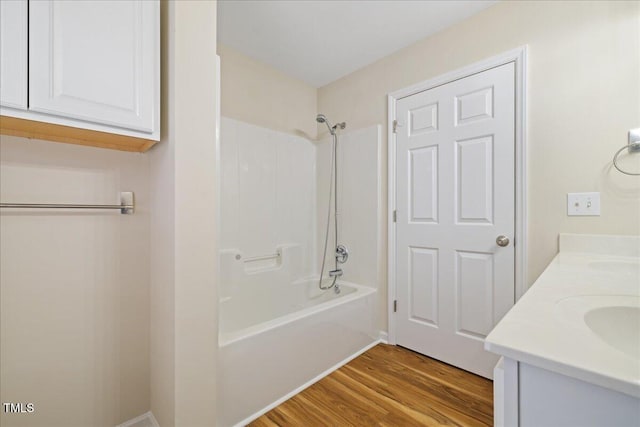 bathroom with double vanity, bathtub / shower combination, and wood finished floors