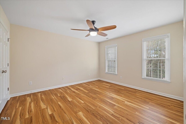 empty room featuring ceiling fan, light wood-type flooring, and baseboards