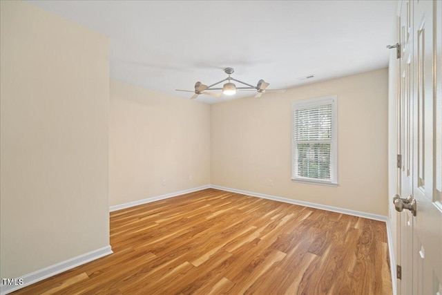 unfurnished room with light wood-style flooring, a ceiling fan, and baseboards