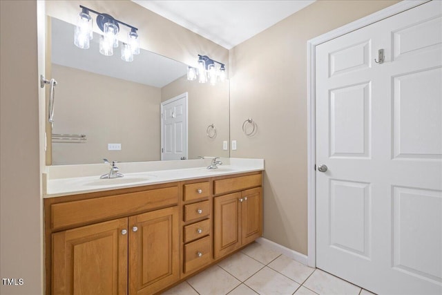 bathroom featuring tile patterned flooring, double vanity, baseboards, and a sink