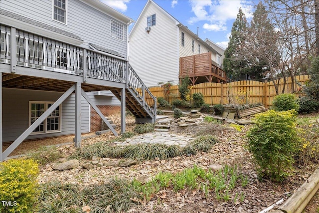 view of yard featuring stairs, a deck, and fence