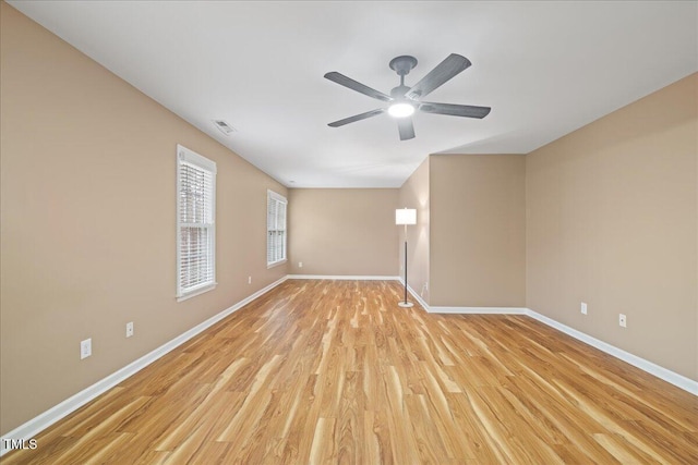 unfurnished room featuring visible vents, a ceiling fan, light wood-type flooring, and baseboards