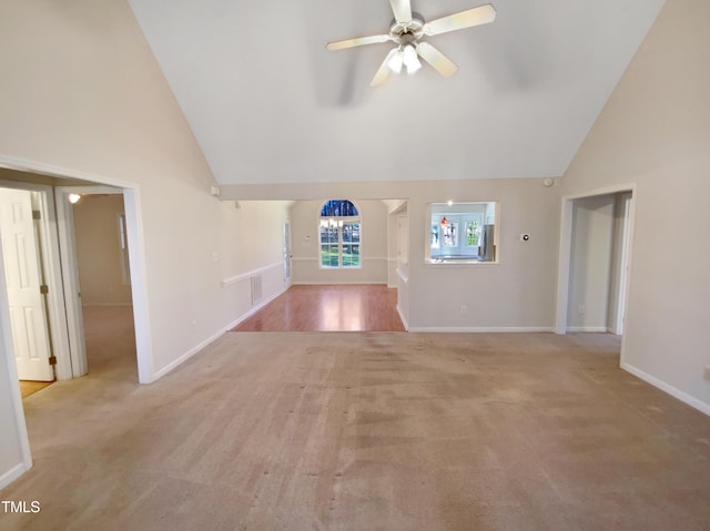 unfurnished living room with light carpet, baseboards, high vaulted ceiling, and ceiling fan