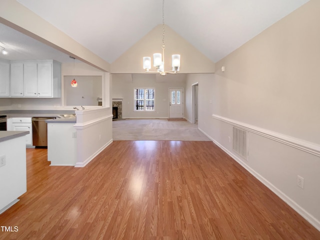 kitchen featuring visible vents, light wood-style floors, a notable chandelier, white cabinetry, and stainless steel dishwasher