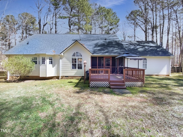 rear view of house featuring crawl space, a deck, a shingled roof, and a yard