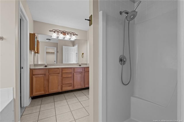 bathroom featuring tile patterned floors, double vanity, a shower, and a sink