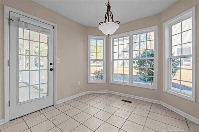 unfurnished dining area with light tile patterned floors, visible vents, and baseboards