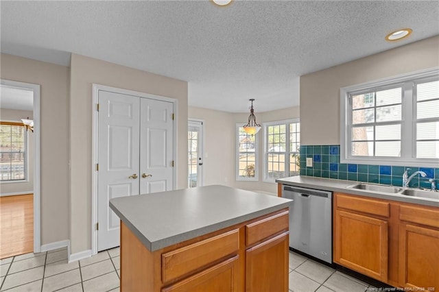 kitchen featuring dishwasher, light tile patterned flooring, tasteful backsplash, and a sink