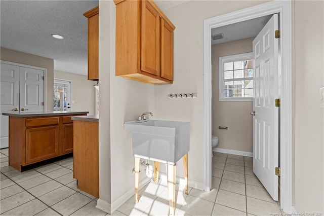 bathroom with tile patterned floors, visible vents, toilet, baseboards, and vanity