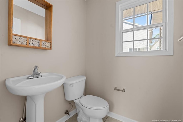 bathroom with toilet and baseboards