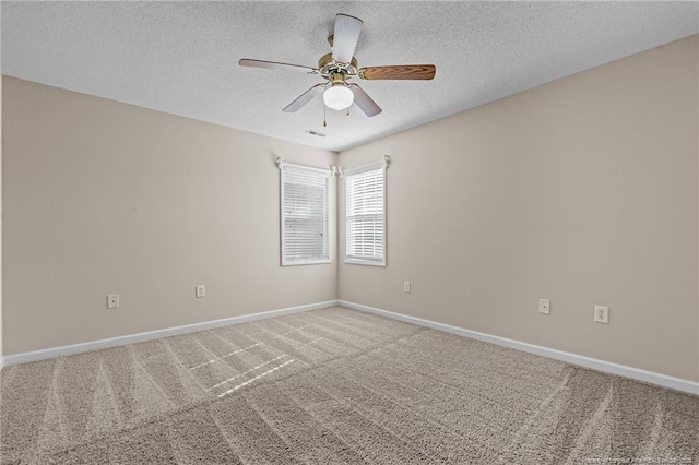 carpeted empty room with visible vents, ceiling fan, a textured ceiling, and baseboards