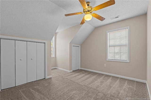 bonus room featuring vaulted ceiling, visible vents, a textured ceiling, and carpet floors