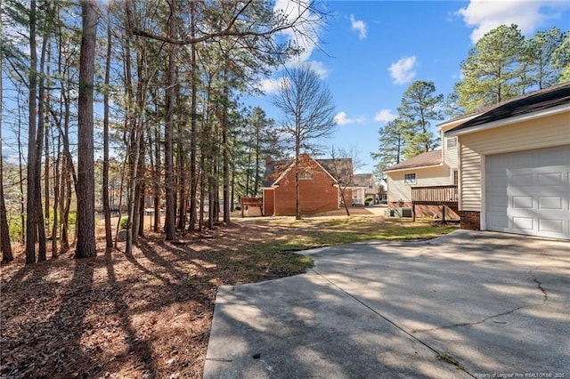 view of yard featuring driveway and a garage