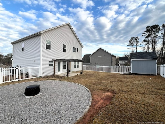 back of property featuring a storage shed, an outdoor structure, a fenced backyard, a patio area, and a gate