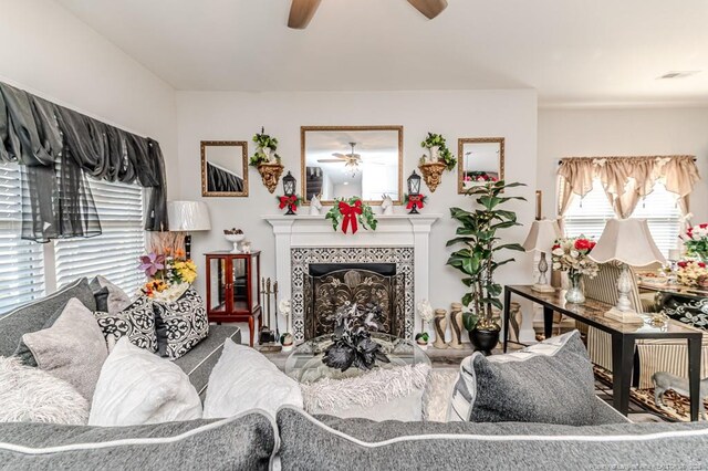 living area with a ceiling fan and a fireplace