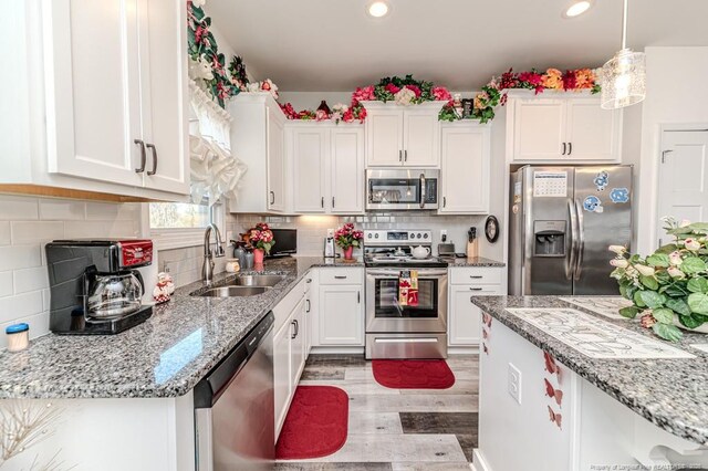 kitchen featuring a sink, white cabinets, light wood-style flooring, and stainless steel appliances