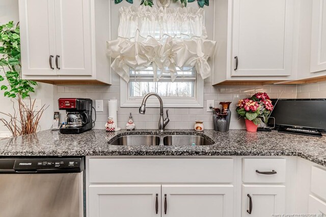 kitchen featuring a sink, backsplash, stainless steel dishwasher, and white cabinets