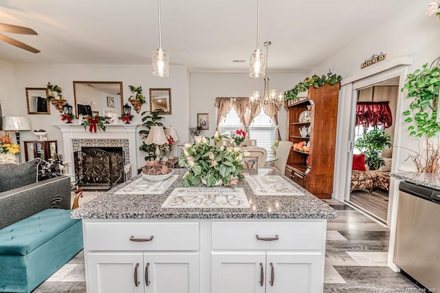 kitchen featuring a wealth of natural light, light stone counters, and dishwasher