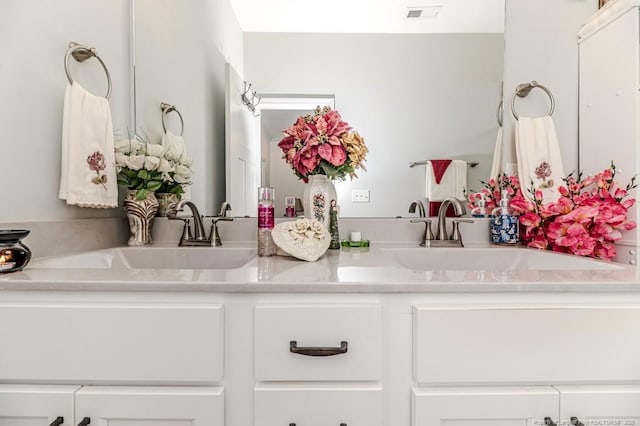 bathroom featuring double vanity, visible vents, and a sink