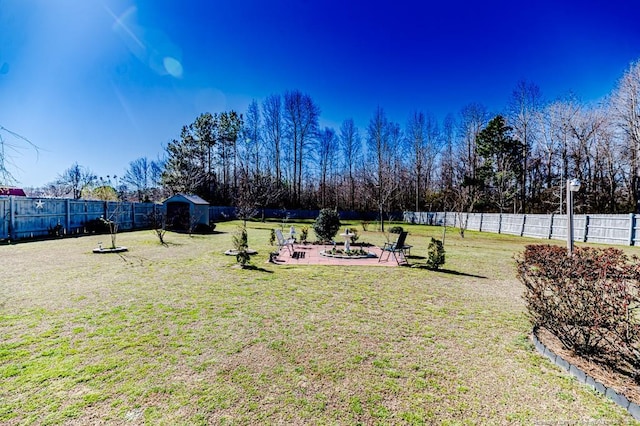 view of yard featuring a storage unit, an outdoor structure, a fenced backyard, and a patio area