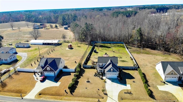 birds eye view of property featuring a rural view and a wooded view