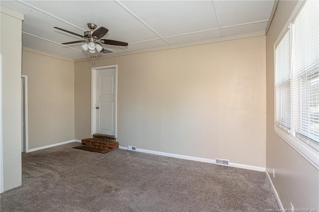 spare room with visible vents, a ceiling fan, baseboards, and carpet floors