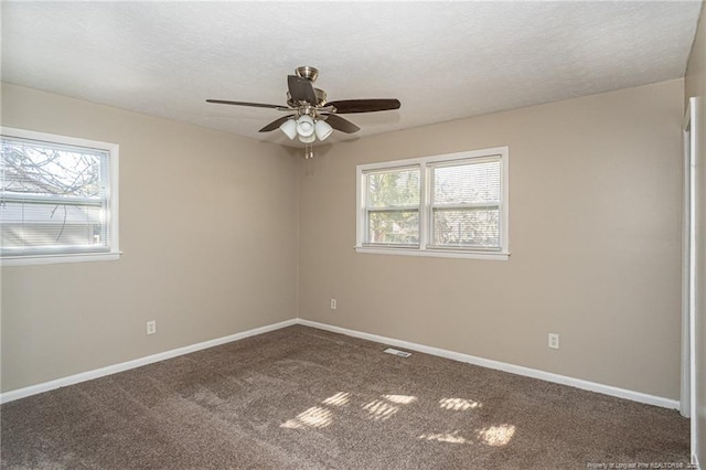 carpeted spare room with plenty of natural light, ceiling fan, a textured ceiling, and baseboards