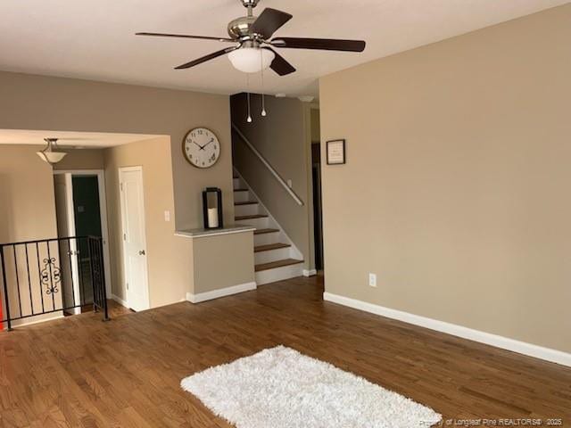 empty room with stairway, baseboards, and wood finished floors