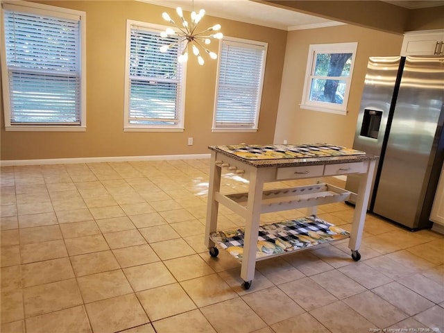 dining room featuring a chandelier, baseboards, light tile patterned flooring, and ornamental molding