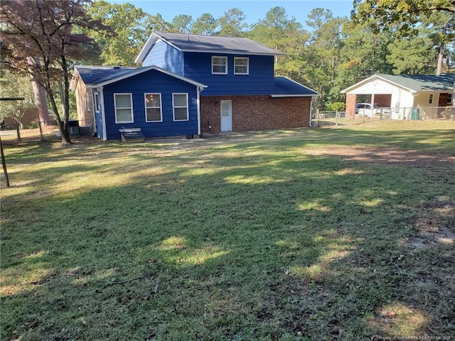 view of front of home featuring a front yard, fence, and brick siding