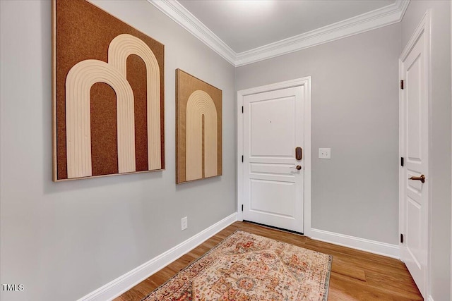 entrance foyer with wood finished floors, baseboards, and ornamental molding