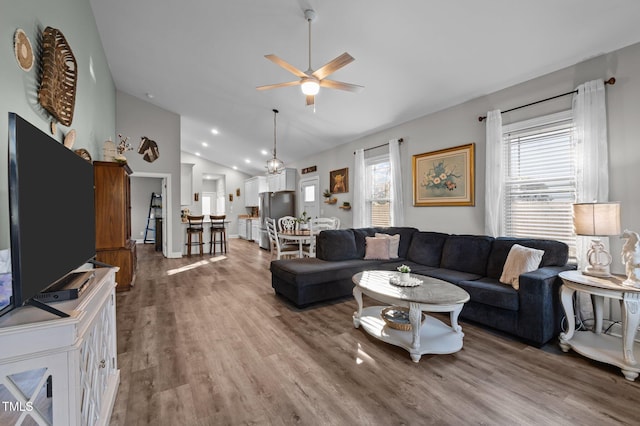 living area featuring wood finished floors, a ceiling fan, and high vaulted ceiling