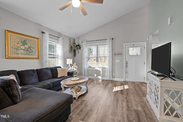 living area with wood finished floors, a ceiling fan, baseboards, and high vaulted ceiling