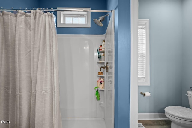 full bath with a shower with curtain, baseboards, and toilet