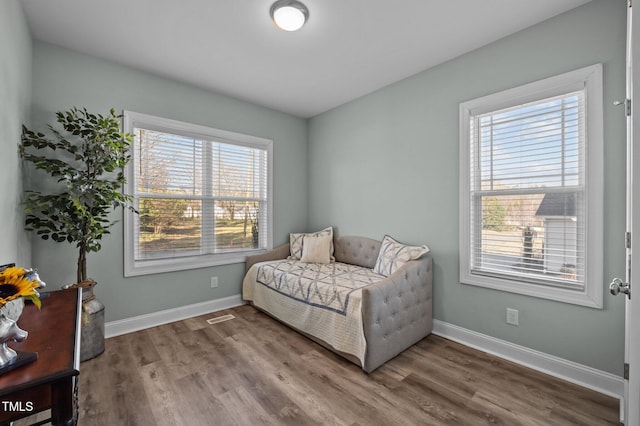 living area with visible vents, baseboards, and wood finished floors