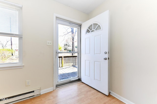 foyer entrance with light wood finished floors, plenty of natural light, baseboards, and baseboard heating