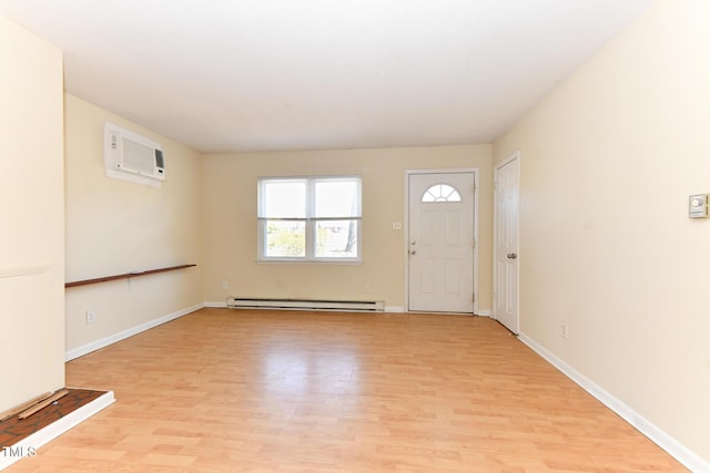 foyer featuring light wood-type flooring, a baseboard radiator, baseboards, and an AC wall unit